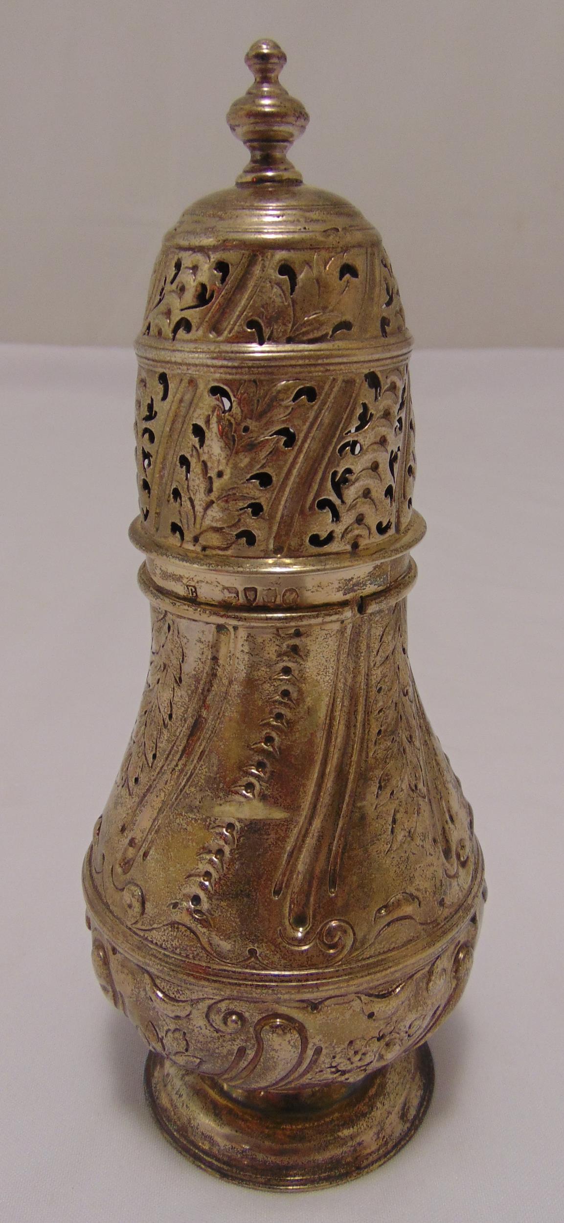 A Victorian hallmarked silver sugar castor, baluster form chased with leaves and scrolls on raised