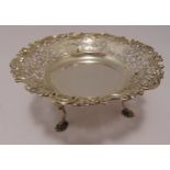 A hallmarked silver cake stand, scroll pierced, circular with floral and shell border on three