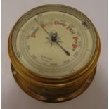 A wall mounted brass barometer, circular with silvered dial, 18cm diameter