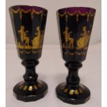 A pair of continental amethyst faceted glass vases with gilded classical decoration on raised bases,