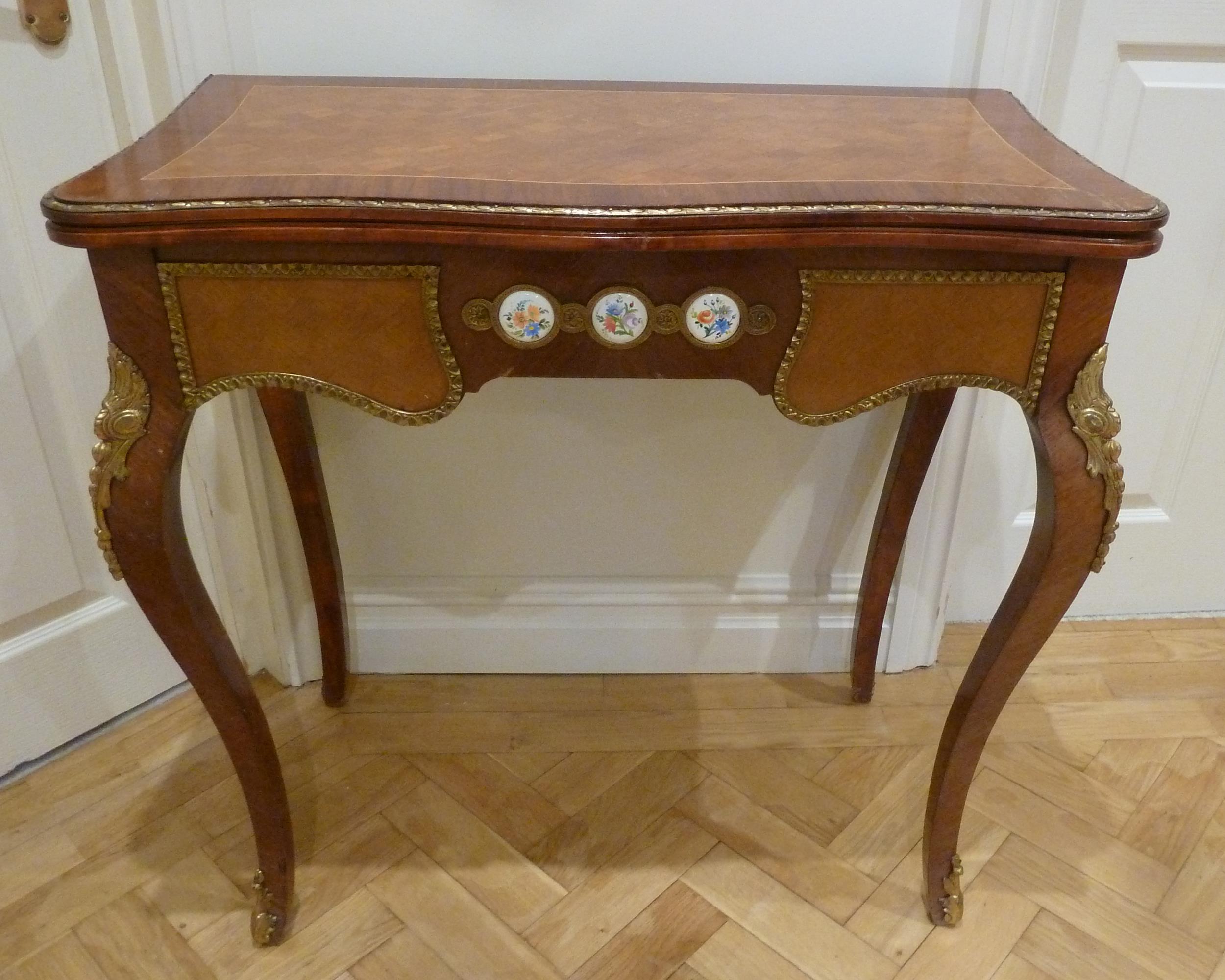 A French style inlaid rectangular games table with applied porcelain roundels and gilded metal