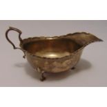 Hallmarked silver sauce boat, oval with double scroll handle on three stepped hoof feet, Sheffield