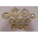 Two hallmarked silver shell shaped nut dishes, another shell shaped dish, a set of six white metal