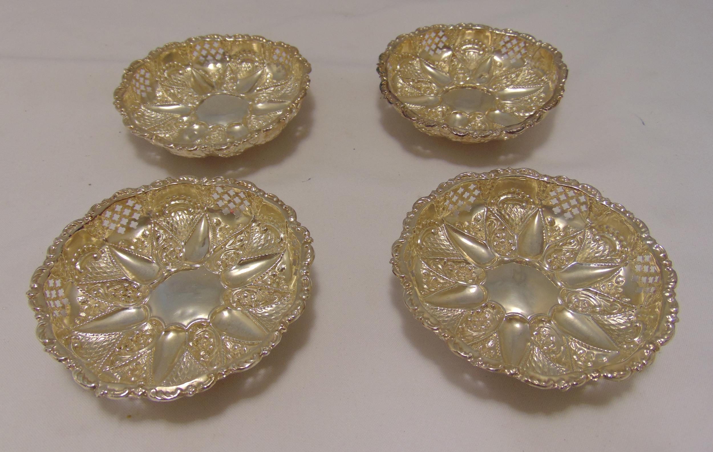 Four Victorian hallmarked silver bonbon dishes, shaped circular, pierced sides on three ball feet,