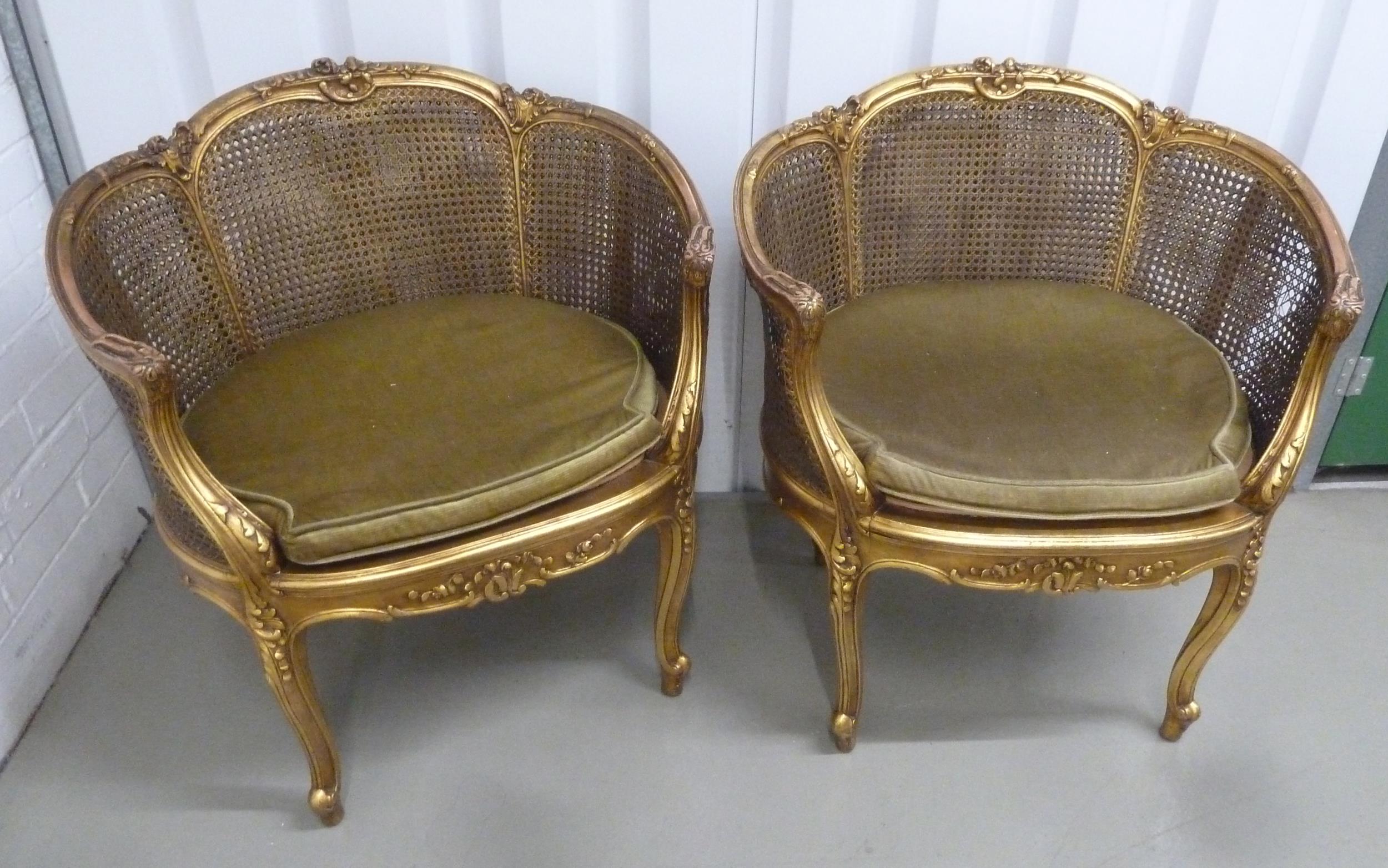 A pair of French style gilded wood and bergere armchairs with removable upholstered seats on four