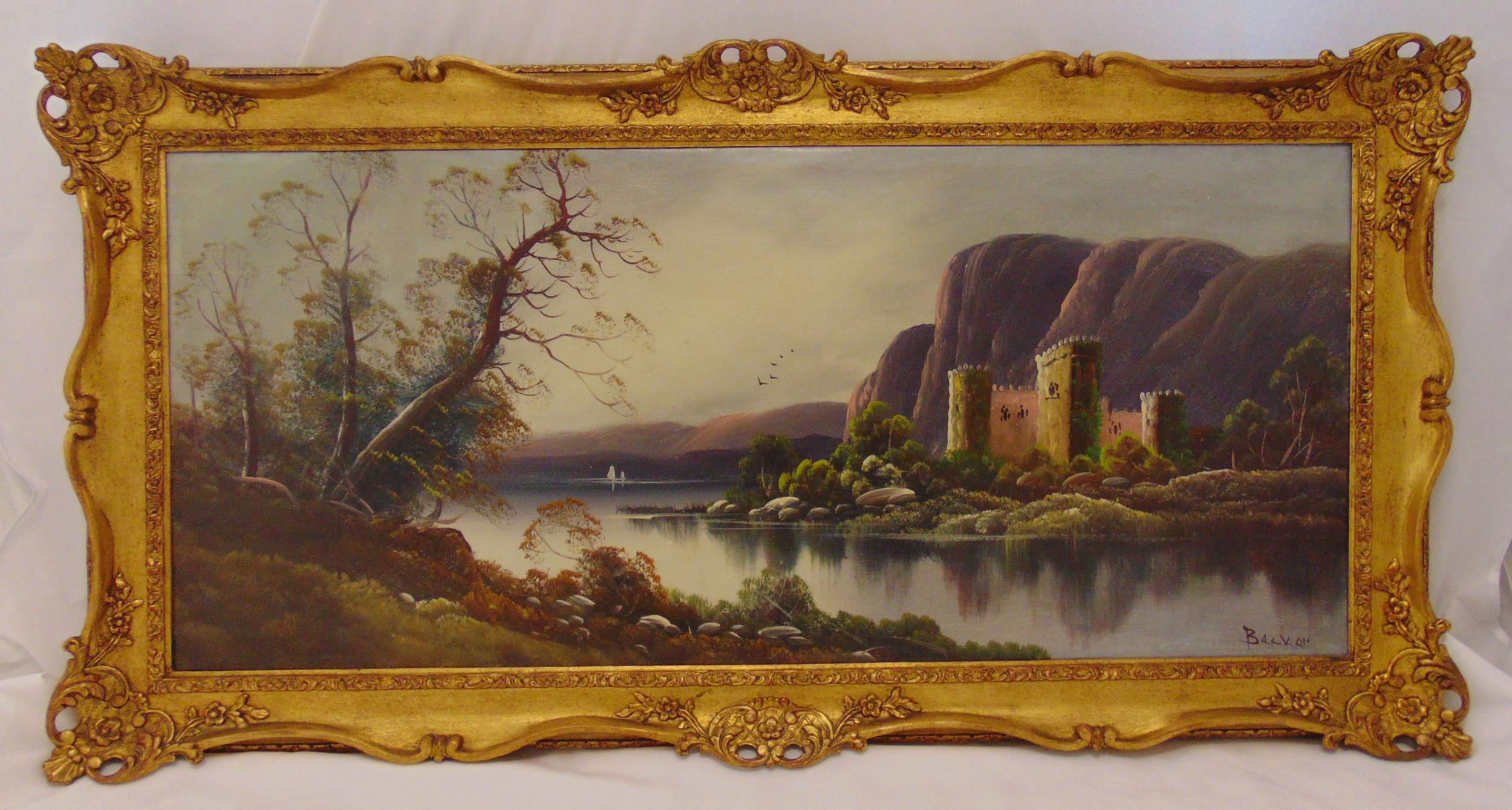 A framed oil on canvas landscape with a lake and a castle in the background, indistinctly signed