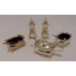 A hallmarked silver five piece condiment set to include blue glass liners and three condiment