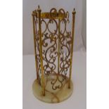 A gilded metal and onyx umbrella stand, scroll pierced cylindrical form on circular onyx base,