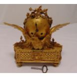 A French gilt metal mantle clock of globular form supported by an eagle on shaped rectangular base