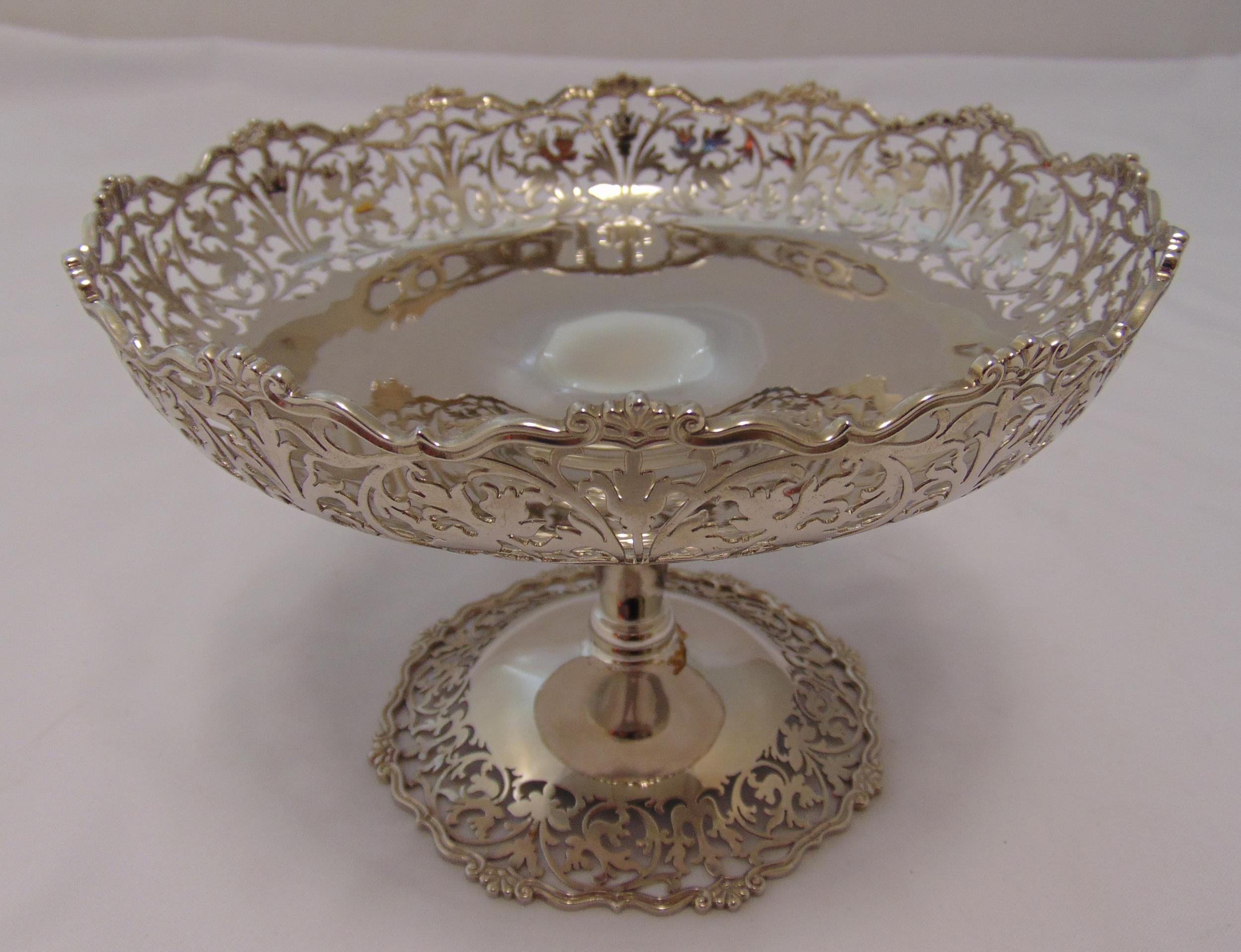 A hallmarked silver cake stand, circular with scroll and leaf pierced border on tapering stem and