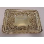 A hallmarked silver dressing table tray, rounded rectangular chased with scrolls, flowers and