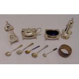 A hallmarked silver three piece condiment set, a pepperette, various condiment spoons and a napkin