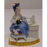A continental porcelain figurine of a seated lady at her dressing table on raised shaped base, marks