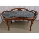 A late 19th century French bedroom seat, shaped oval carved with swags with bergere seat, on four