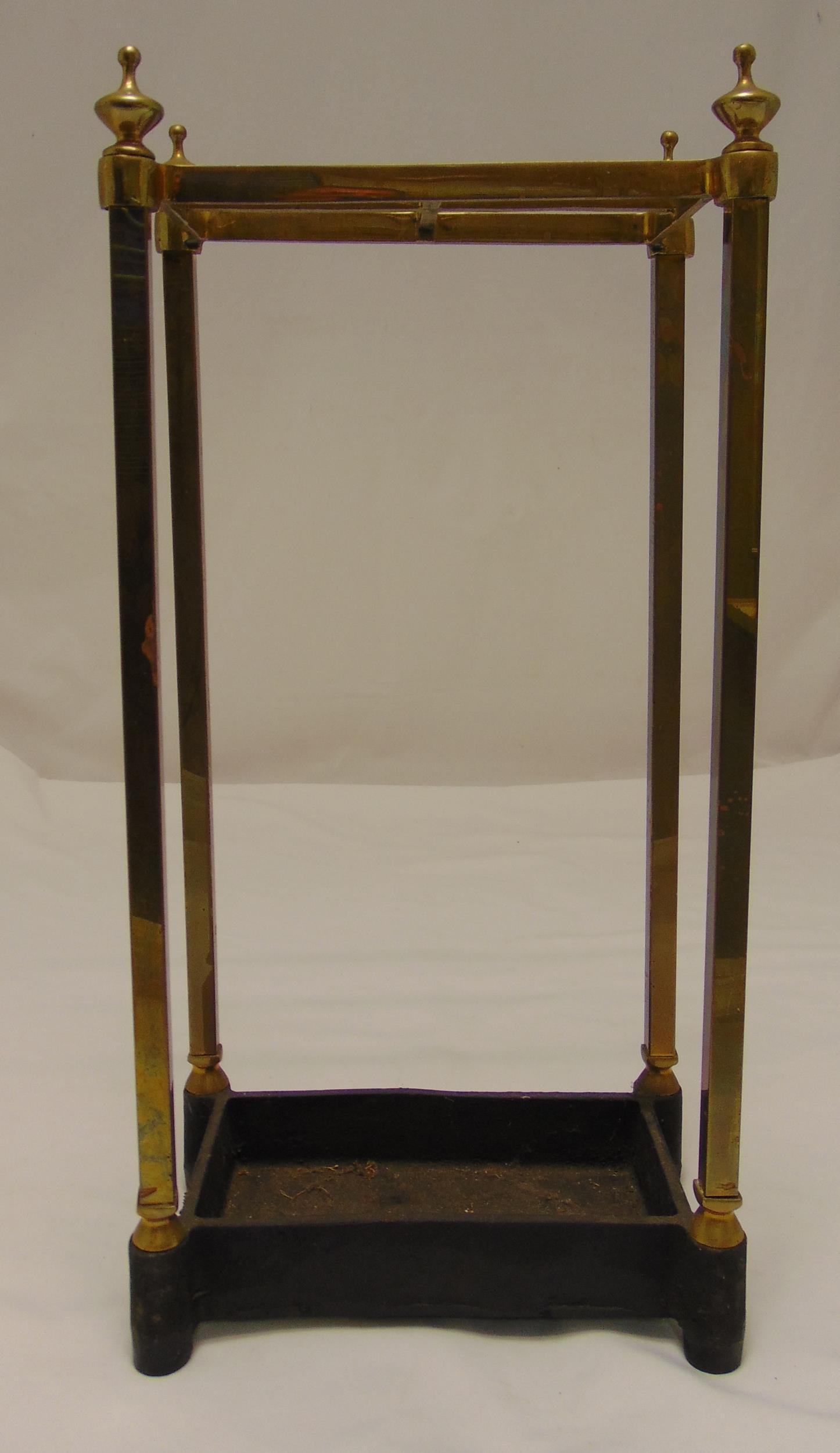 A brass and metal rectangular umbrella and stick stand on four tubular feet surmounted by urn