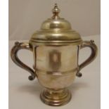 A hallmarked silver trophy cup, vase form with scroll handles and domed pull off cover, Birmingham