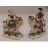 A pair of late 19th century continental figurines of a lady and gentleman riding rams on raised