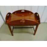A mahogany butlers tray and stand of customary form with inset handles and brass hinges, the stand