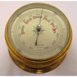 A wall mounted brass barometer, circular with white enamel dial, 18cm diameter