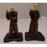 Two oriental carved wooden figurines on rounded rectangular bases, 20cm (h)