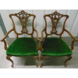 A pair of Edwardian occasional armchairs with scrolling arms and scroll pierced backs on four leaf