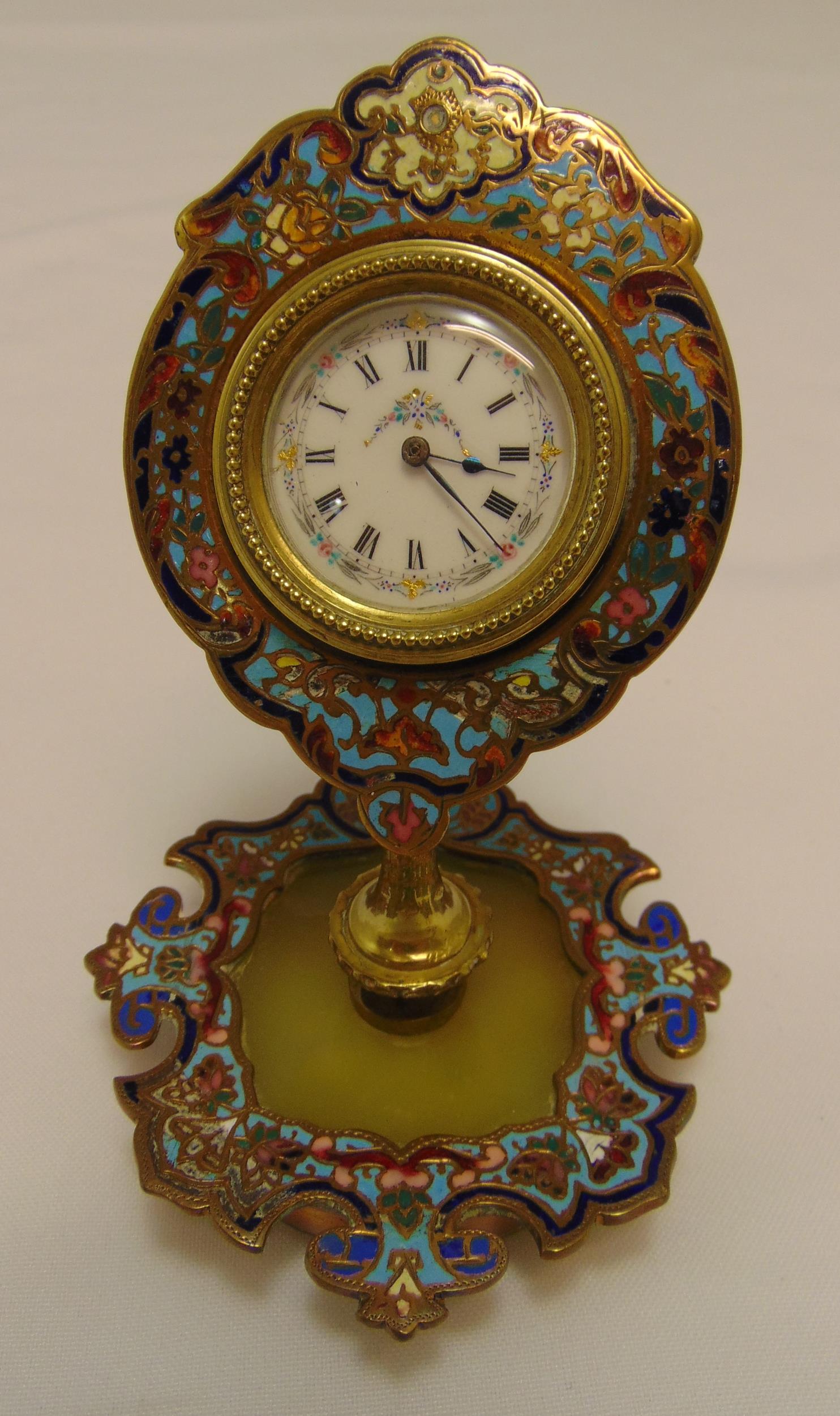 A Swiss gilded metal and cloisonn‚ desk clock with white enamel dial and Roman numerals on shaped
