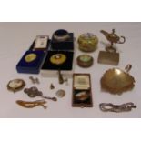 A quantity of collectables to include white metal covered boxes, brooches and an oil lamp