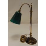 An early 20th century desk lamp with adjustable green glass shade on raised circular base, 56cm (h)