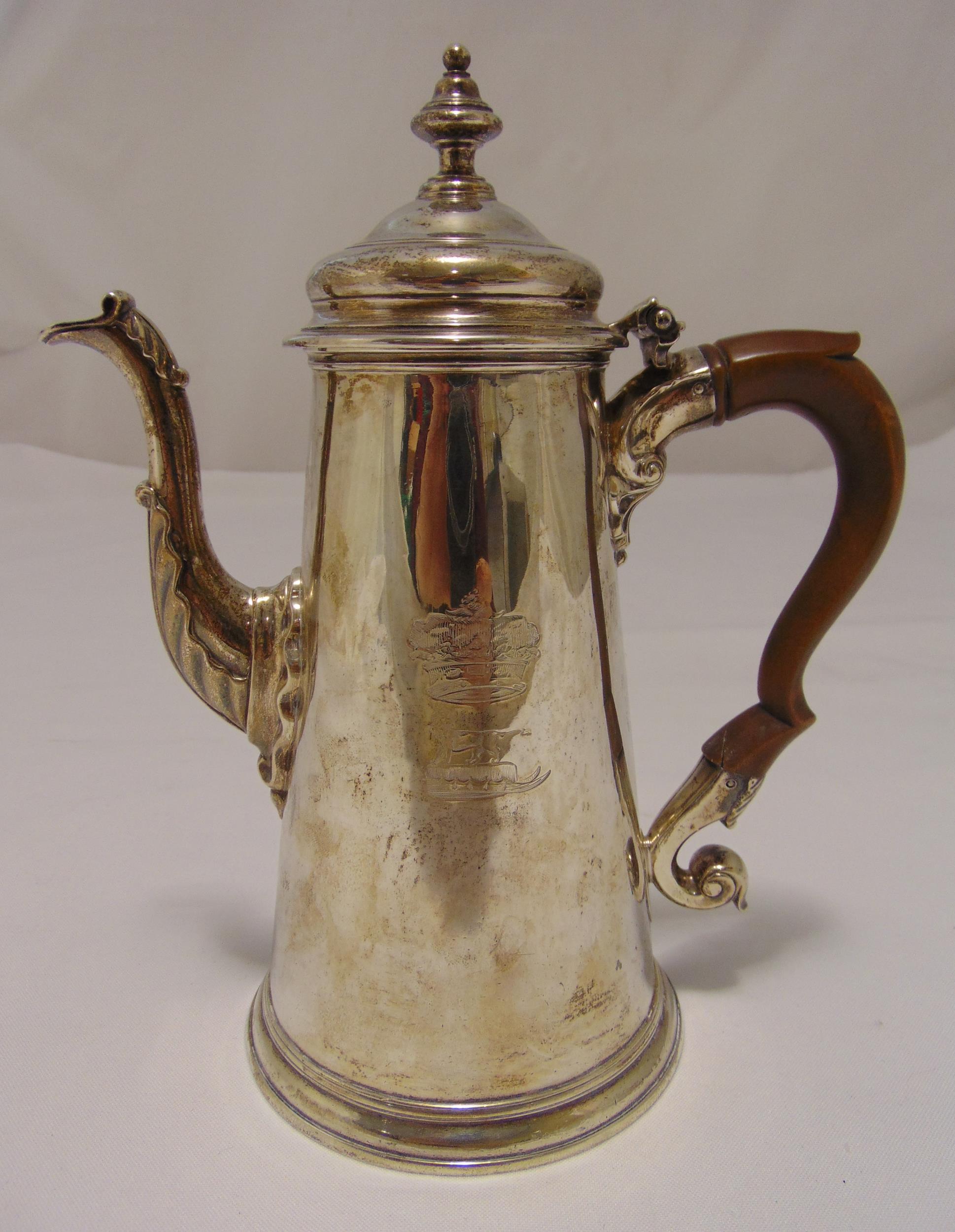 A George II hallmarked silver coffee pot, tapering cylindrical with leaf mounted spout and double