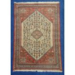 A Middle Eastern wool carpet cream ground with red border with repeating pattern, 149 x 102cm