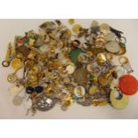 A quantity of costume jewellery to include badges, tie clips, rings and charms