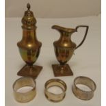 A quantity of hallmarked silver to include a cream jug, a sugar sifter and three napkin rings,