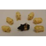 A set of six oriental stylised miniature pigs and a carved wooden pig with a 9ct gold band and