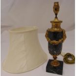 A marble and gilt metal table lamp, oval with floral brass swags on raised square marble base to