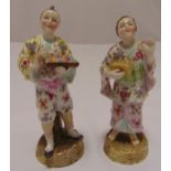 A pair of 19th century continental figurines wearing oriental dress on raised circular bases,