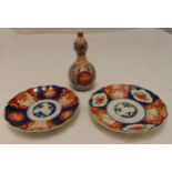 A pair of oriental Imari pattern wall plates and a double gourd shaped vase, plates 22cm (dia)