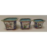 A set of three graduated oriental metal and enamel plant holders decorated with flowers and