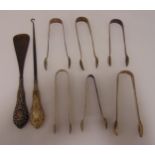 Six hallmarked silver sugar tongs, a button hook with silver handle and a shoehorn with silver