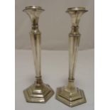 A pair of hallmarked silver table candlesticks tapering cylindrical on stepped hexagonal bases,