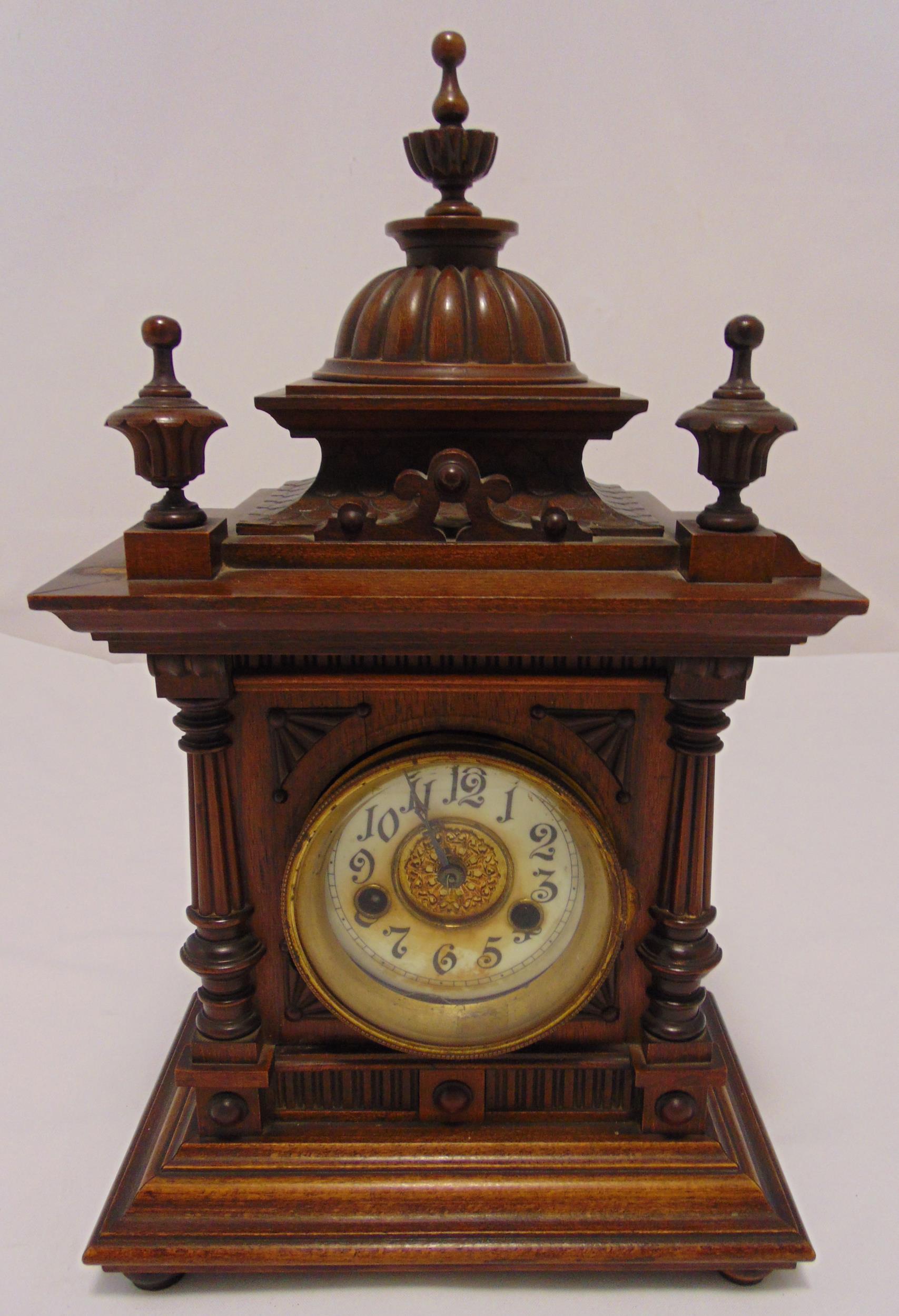 An oak cased mantle clock two train movement in architectural wooden frame, column supports and