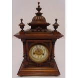 An oak cased mantle clock two train movement in architectural wooden frame, column supports and