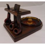 An early 20th century pipe stand shaped rectangular, the mahogany pipe stand supporting three
