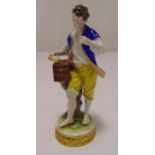 A Dresden figurine of a man holding a bird cage on raised circular base, marks to the base, 19cm (