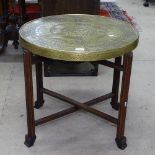 An Egyptian design embossed brass-top table on folding base, W60cm, H58cm
