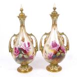 A pair of Royal Worcester ivory porcelain vases and covers, hand painted and gilded floral