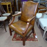 A studded brown leather upholstered open armchair