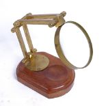 A Nauticalia of London brass instrument maker's desktop magnifying glass, on wood base