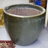 A large green glazed terracotta garden pot