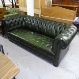 An early 20th century green studded leather upholstered and horse hair filled Chesterfield settee,