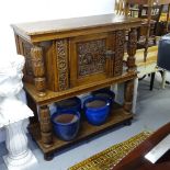 A light oak court cupboard, in 17th century style, with panelled door and allover relief carved